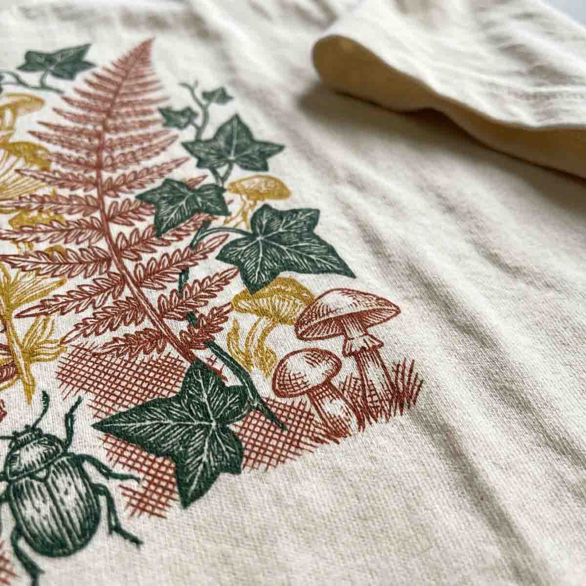 Macro close-up of an intricate botanical print on cream cotton