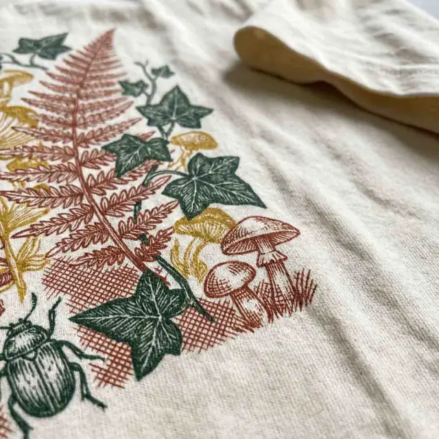 Macro close-up of an intricate botanical print on cream cotton